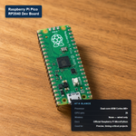 Raspberry Pi Pico RP2040 development board with at-a-glance spec card showing 26 GPIO pins and dual-core processor