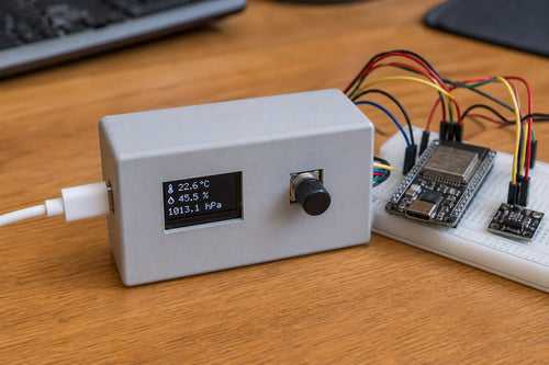 Small enclosure with 0.96 inch OLED display and rotary encoder knob, ESP32-S3 and AHT20 sensor on breadboard