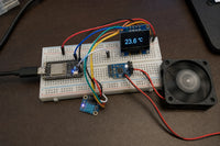 Breadboard demo with ESP32-C3 SuperMini, AHT20 sensor, OLED display showing target temperature, and a 40mm fan spinning