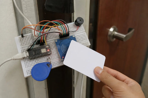 Breadboard with ESP32-C3 SuperMini, RC522 RFID reader module and buzzer, hand tapping an RFID card near a door