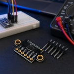 VL53L0X time-of-flight distance sensor board with header pins on an electronics workbench near a breadboard and multimeter.